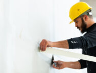 worker plastering gypsum board wall.