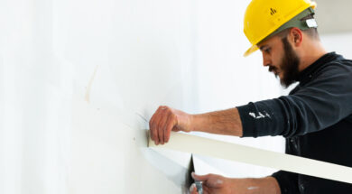 worker plastering gypsum board wall.