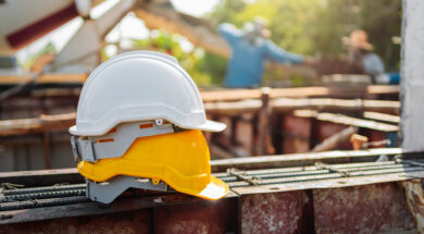 white and yellow helmet on steel in construction site