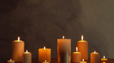 Group of burning candles on black table, space for text