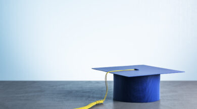 Blue graduation cap on wooden table