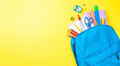 Back to school. School bag with supplies for school on yellow ba