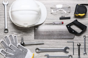 Set of construction tools on light wooden background