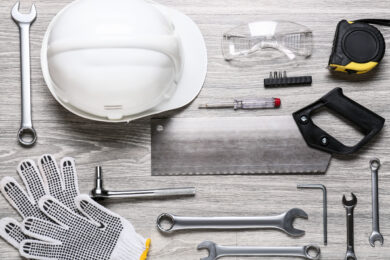 Set of construction tools on light wooden background