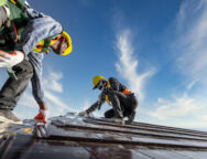 Two male workers wearing safety clothes Installing the roof tile