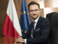Minister_rozwoju_i_technologii_Waldemar_Buda,_poziom,_w_tle_flagi_PL_i_UE