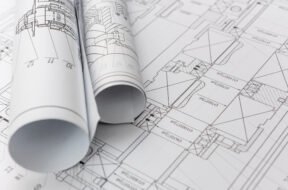 Technical drawings with blueprints in rolls close up. Engineerin