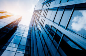 Modern office building against blue sky, blue tone.