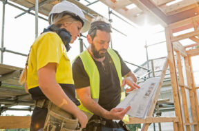 male and female construction workers discuss the building plans inside the building site