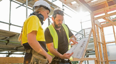 male and female construction workers discuss the building plans inside the building site