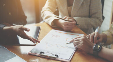 Businesswoman holding pens and holding graph paper are meeting t