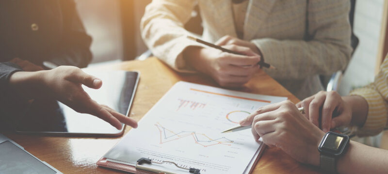 Businesswoman holding pens and holding graph paper are meeting t
