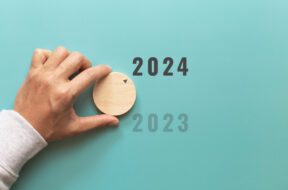 Man hand choose number 2024 on blue background. countdown to 202