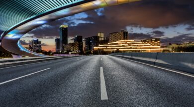 Asphalt,Road,And,Bridge,With,Modern,City,Skyline,At,Night