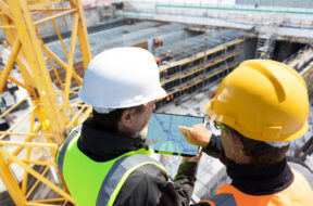 Two,People,Architect,Engineer,Worker,On,Major,Constructionsite,Checking,Progress